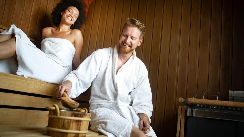 Beautiful young couple sitting together in a sauna spa