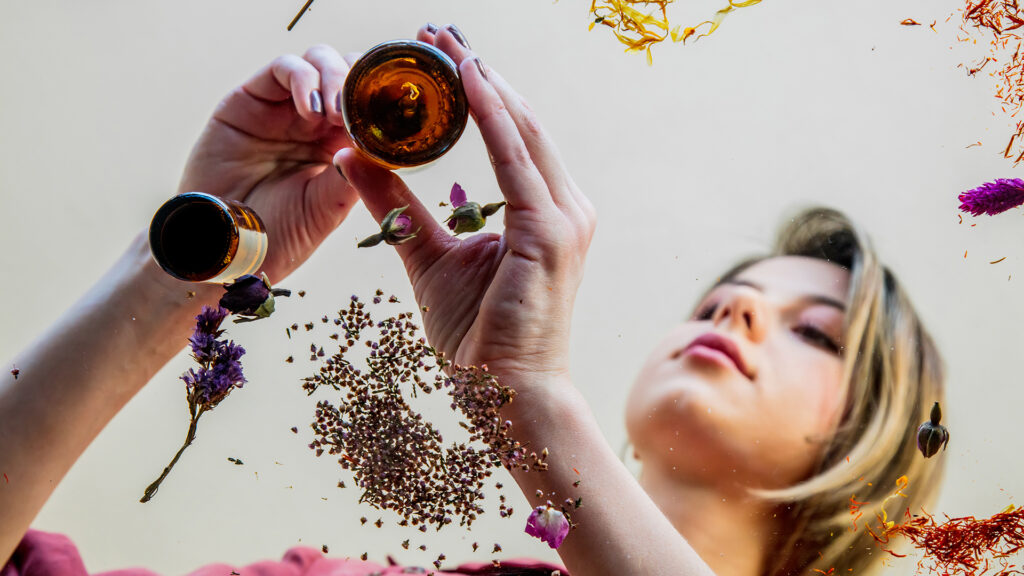 Looking up at a young woman preparing herbs and flowers.